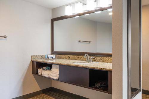 a bathroom with a sink and a large mirror at Branson Hillside Hotel in Branson