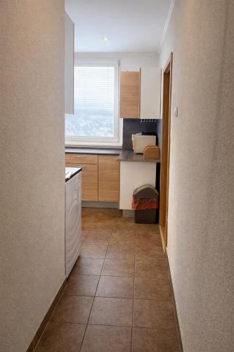 a small kitchen with a white dishwasher and a window at Apartmán MARKI in Malacky