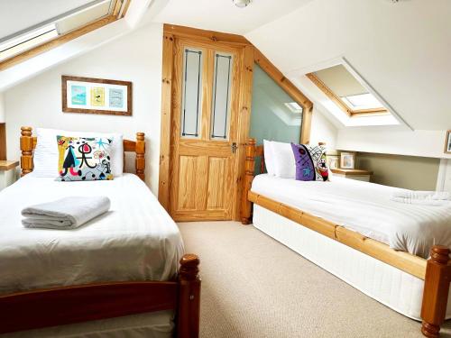 two beds in a small room with a door at Thorpe House - Fylingthorpe in Fylingthorpe