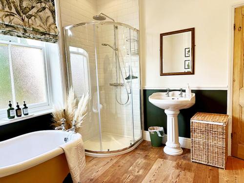 a bathroom with a shower and a tub and a sink at Thorpe House - Fylingthorpe in Fylingthorpe