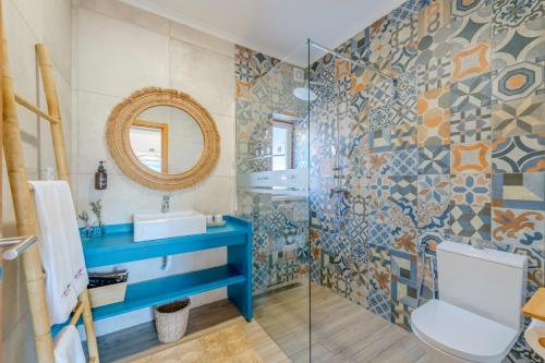 a bathroom with a toilet and a sink and a mirror at Casa do Arlindo in São Bartolomeu de Messines