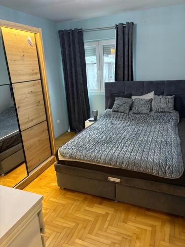 a bedroom with a bed and a dresser and a mirror at Apartman 23 in Belgrade