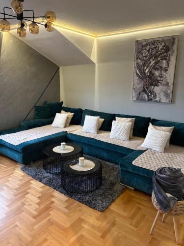 a living room with a blue couch and two tables at Apartman 23 in Belgrade