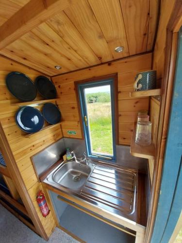a small bathroom with a sink and a window at EcoPod Holidays in Alton