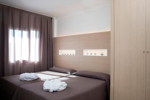 two beds in a bedroom with towels on them at Aparthotel Acualandia in Peniscola
