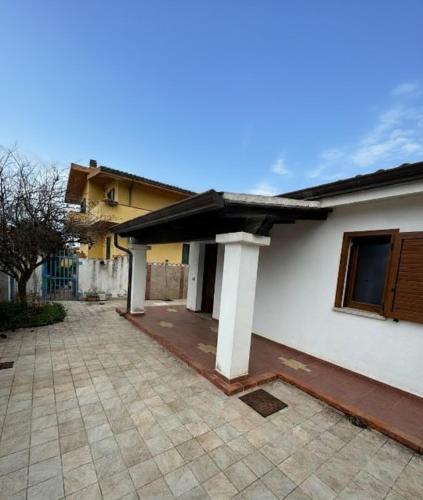 a white house with a patio with a roof at Da Anna Casa Vacanza Al Mare in Santa Lucia