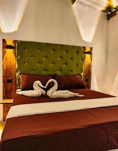 a bedroom with a bed with two swans on it at Cocos cabana in Ilandaiyadi
