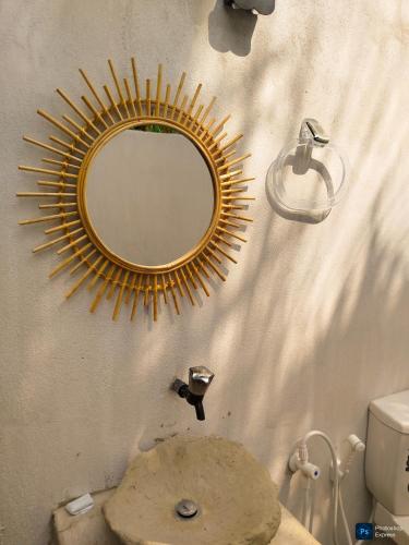 a mirror on the wall of a bathroom with a toilet at Cocos cabana in Ilandaiyadi