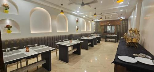 a restaurant with a row of tables and sinks at Hotel DC in Bacha