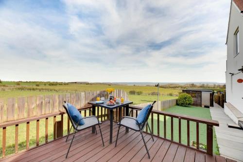 a patio with a table and chairs on a deck at Brackenrigg Embleton in Embleton