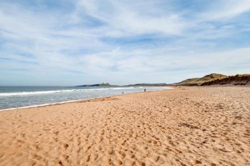 a sandy beach with a view of the ocean at Brackenrigg Embleton in Embleton