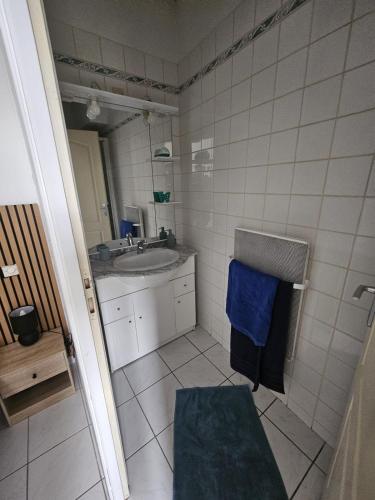 a bathroom with a sink and a blue towel at F2 avec jardin in Nemours