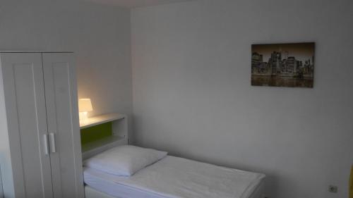a small room with a bed and a picture on the wall at Appartements Katharina in Bremerhaven