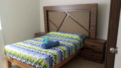 a bedroom with a bed with a wooden head board at Cómodo y lindo departamento cerca de las playas in Mezcales
