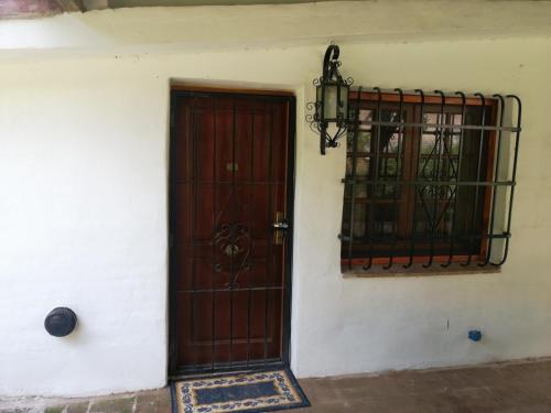 a brown door and a window on a building at Casa Canela in La Cumbre
