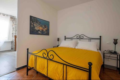a bedroom with a bed with a yellow blanket at EvasRooms Open space in Vernazza