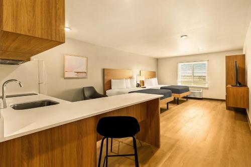 a hotel room with a kitchen and a bedroom at LivAway Suites Phoenix Tolleson in Phoenix