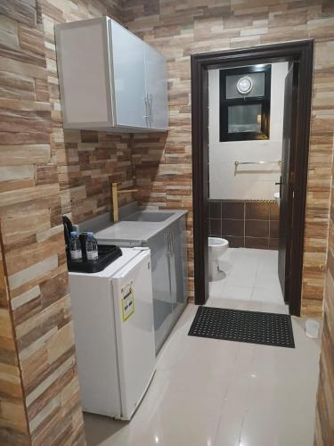 a small kitchen with a stove and a toilet at الجوهرة بارك للشقق المخدومة 6 in Riyadh