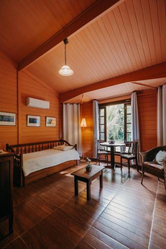 a bedroom with a bed and a table at Hotel Solar Fazenda Do Cedro in Itaipava
