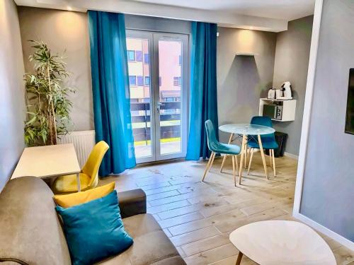 a living room with a couch and a table at Le Genev Altitude - Studio Lumineux - Vue Montagne in Collonges-sous-Salève