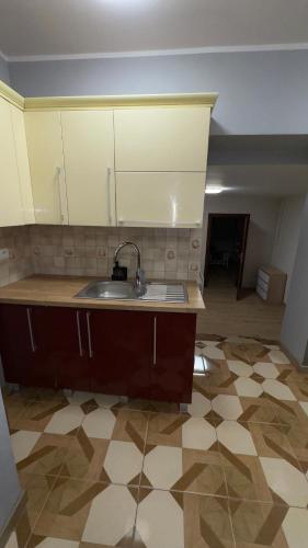 a kitchen with a sink and a tile floor at Apartament 11 Słoneczna in Ełk