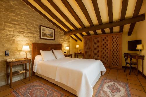a bedroom with a large white bed in a room at Posada Mayor de Migueloa in Laguardia