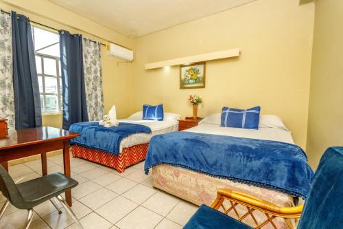 a hotel room with two beds and a desk at Mirador Hotel in Corozal