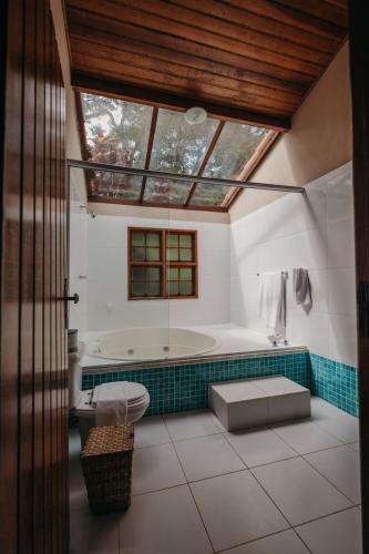 a bathroom with a bath tub and a window at Hotel Solar Fazenda Do Cedro in Itaipava
