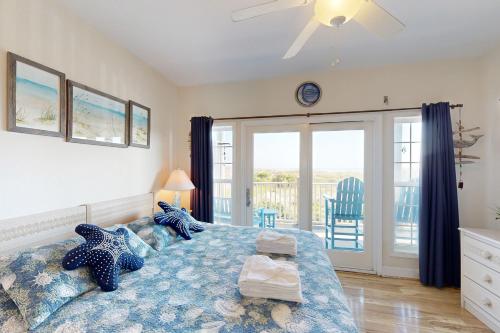 a bedroom with a bed and a sliding glass door at HADS814 Wahoo 814 #102DS-H in Hatteras