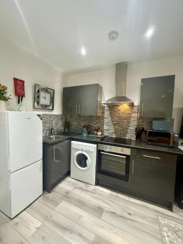 a kitchen with a washing machine and a refrigerator at Brand New Property - Bradford City Centre in Bradford