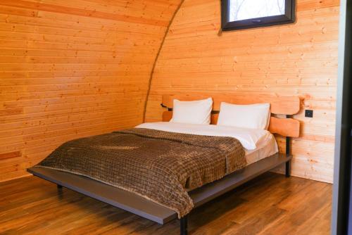 a bedroom with a bed in a wooden wall at Cottage TKESHI in Godogani
