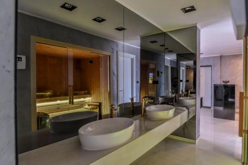 a bathroom with four sinks and a row of mirrors at Aura Villas Skopje in Skopje