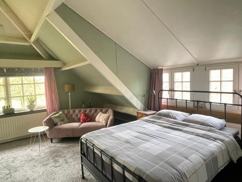 ein Schlafzimmer mit einem Bett und einer Couch in der Unterkunft d'oude hoeve in Rijsbergen