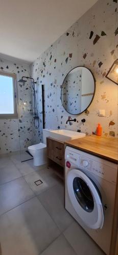 ein Badezimmer mit Waschmaschine und Waschbecken in der Unterkunft Imagio 22 in Sálakos