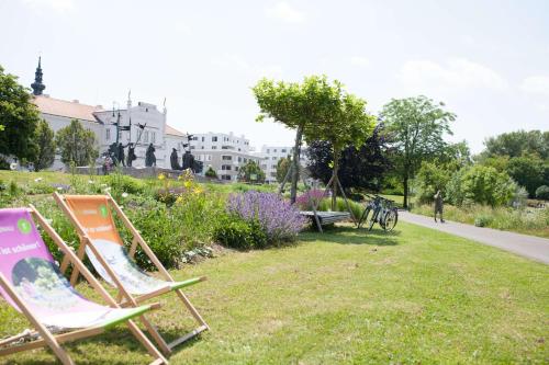 two lawn chairs sitting on the grass in a park at Best Western Hotel Tulln in Tulln