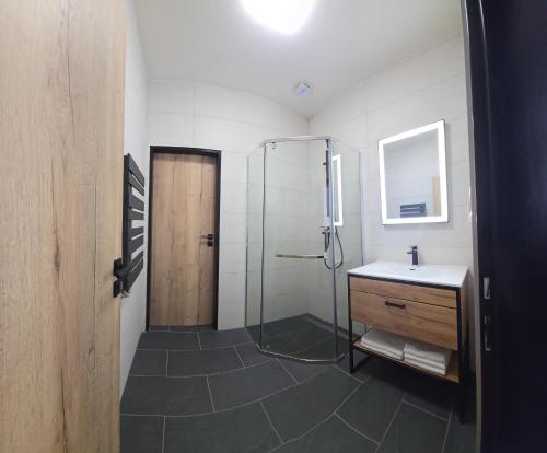 a bathroom with a glass shower and a sink at Sauna Cafee & Beds in Český Těšín