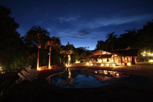 a resort with a swimming pool at night at Pousada do Quilombo in São Bento do Sapucaí