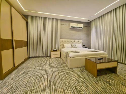 a hotel room with a bed and a table at النخبة الرفيعة للشقق المخدومة in Al Qurayyat