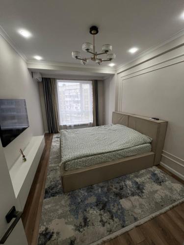 una camera da letto con un letto e una finestra di STA Apartment a Bishkek