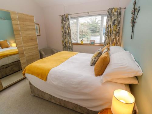 a bedroom with a large bed and a mirror at Blake Lodge in Newquay