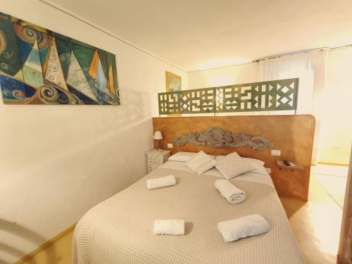 a bedroom with a bed with two towels on it at palazzo beddoro charming apartments in San Pantaleo