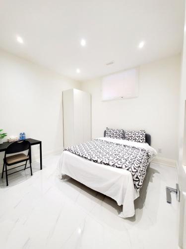 a white bedroom with a bed and a desk at Comfortable Room in Toronto next to Yorkdale mall in Toronto