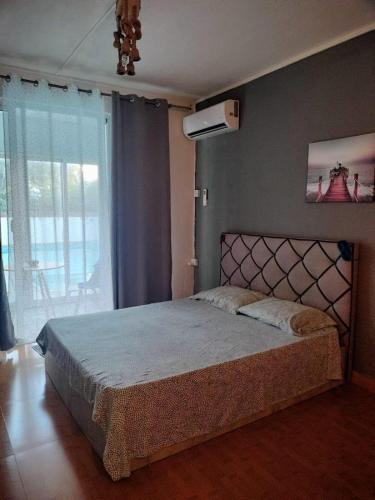 a bedroom with a large bed and a large window at Din villa in Cap Malheureux