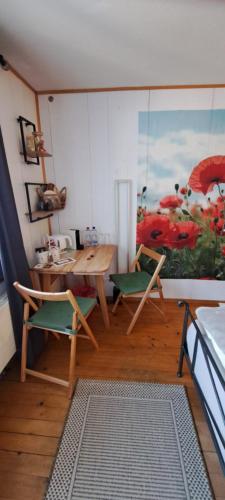 a room with a table and two chairs and a painting at Gadänäscht in Jenaz