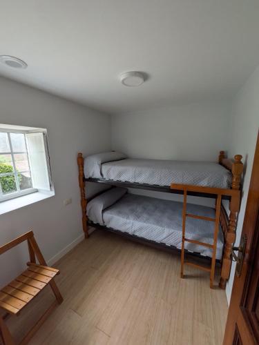 a room with two bunk beds and a window at A Casa do Río Bueu in Bueu