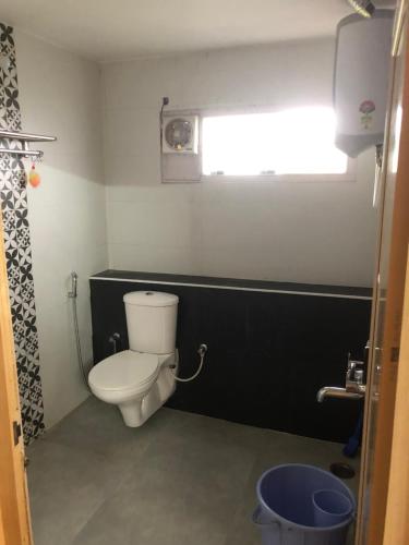 a small bathroom with a toilet and a window at Zioneliteresidency in Kodaikānāl