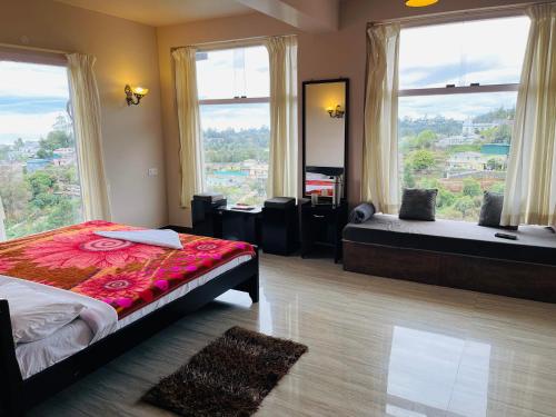 a bedroom with two beds and a large window at Zioneliteresidency in Kodaikānāl