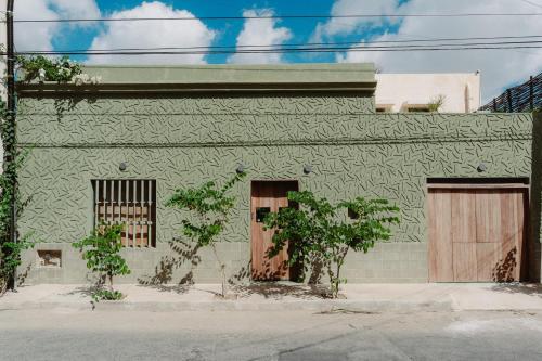 a green building with two doors on the side at Querida Casa - Mérida Centro in Mérida