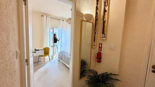 a woman walking into a room with a hallway at 2BR a 400m da praia Surf e Relax a 50min de Lisboa in Santa Cruz