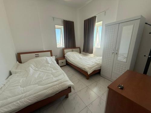 a bedroom with two beds and a dresser in it at Your Comfort Starts Here in Ras al Khaimah